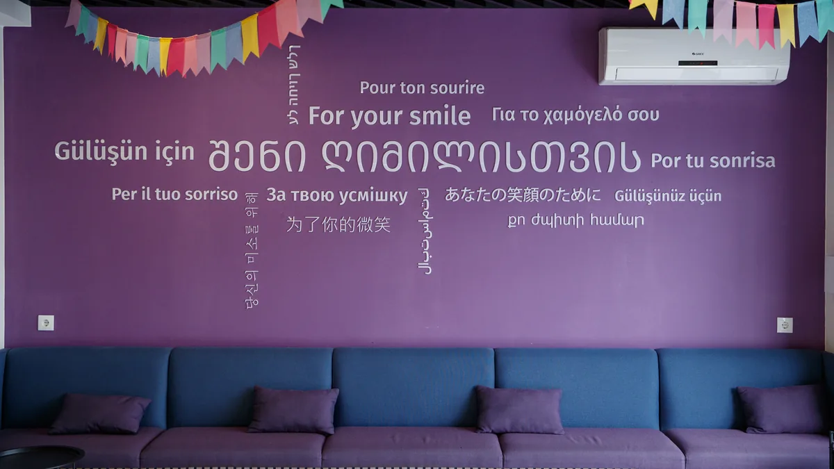 „შენი ღიმილისთვის“ - წარწერა NB Dental-ის მისაღებში სხვადასხვა ენაზე
